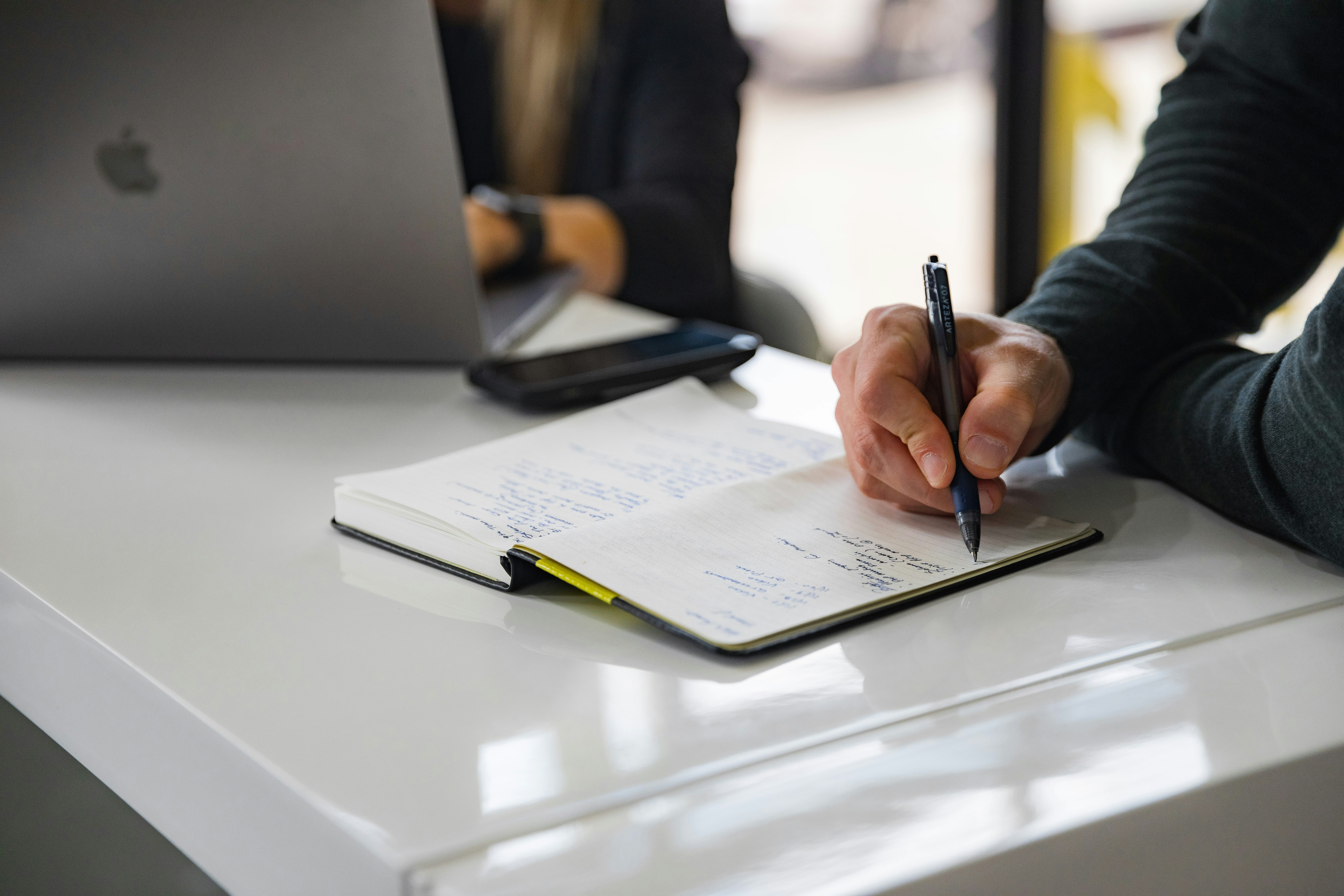 Persona trabajando con documentos en una reunión de trabajo